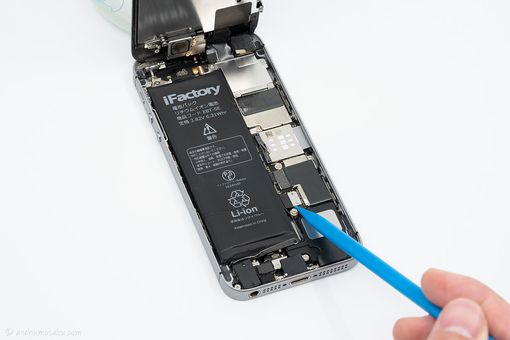 iPhone SE バッテリー交換手順: バッテリーコネクタをヘラ（棒状）の鋭角側で外す