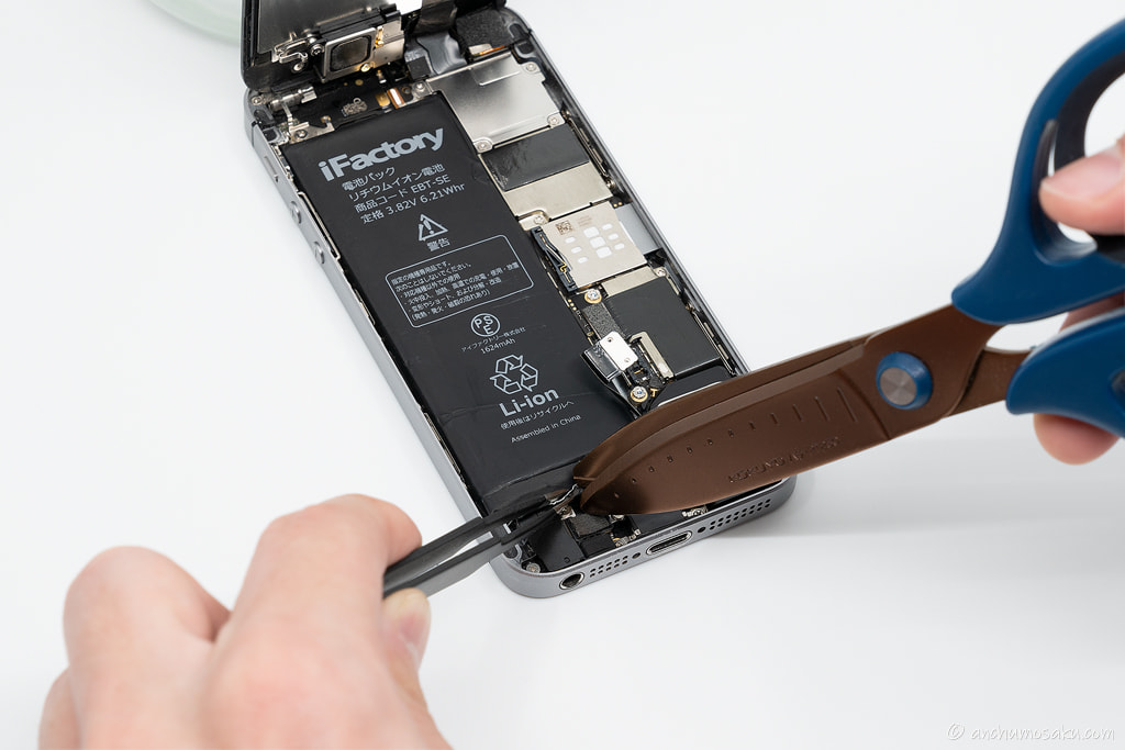 iPhone SE バッテリー交換手順: バッテリー用の黒い両面テープを真ん中で切り分ける